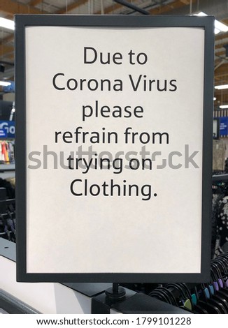 A sign in a shop in the UK saying due to coronavirus pandemic please refrain from trying on shoes, clothes. This is to control the spread of the virus. 
