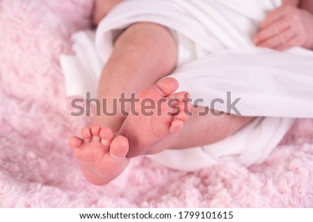 cute newborn baby feet on a white blanket, closeup. selective focus.