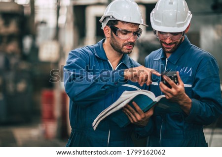 Engineer service team looking at machine service manual text book, Working together as teamwork in factory . Royalty-Free Stock Photo #1799162062