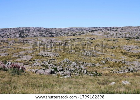 Agrarian landscape. View of the rocky hill, meadow and grassland in autumn.