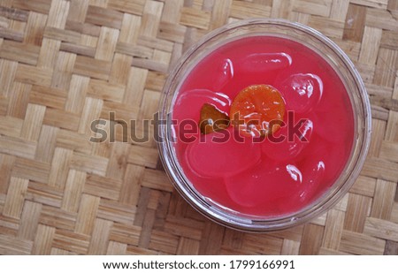 Picture of pink sugar palm fruit with lemon and woven bamboo as blurred background, takjil ramadhan