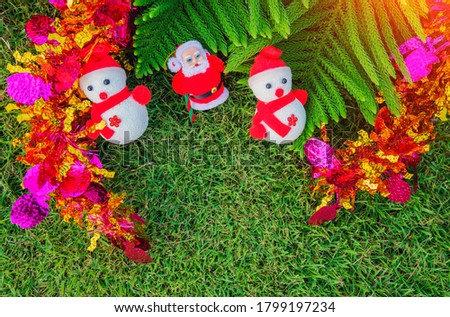 Snow man on green lawn with  Christmas tree, Santa Claus and Snowman on green lawn with Christmas tree as background.