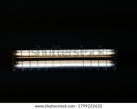 Fluorescent lamp with dark background take photo by mobile phone.