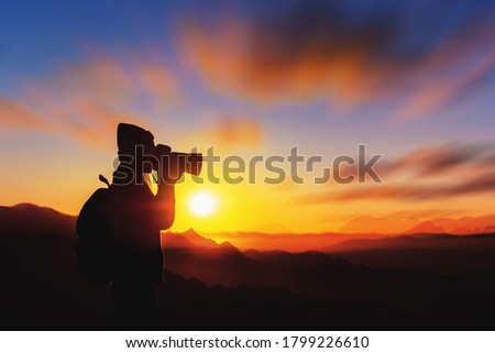 Young woman tourists taking pictures on mountains in Thailand against the background of sunrise in the morning of winter.