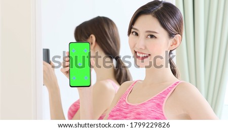 asian sport woman show smart phone with green screen
