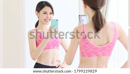 asian woman take selfie in front of mirror with sport wear happily