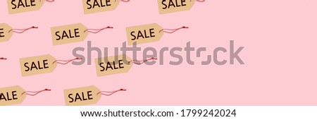 Tags with inscription Sale pattern on a pink pastel background. Creative banner with copy space.