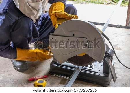 A worker using a fiber machine cutting steel ,with wearing a safety protection