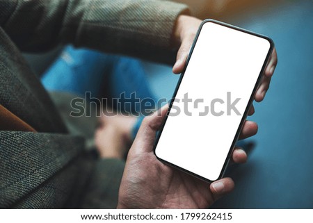 Mockup image of a woman holding and showing mobile phone with blank white desktop screen to someone