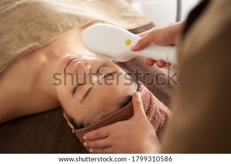 Japanese woman getting a photo facial at an aesthetic salon