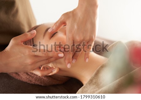 Japanese woman receiving a facial massage at an aesthetic salon Royalty-Free Stock Photo #1799310610