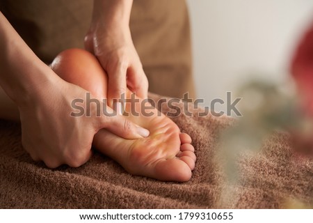 A Japanese woman receives a foot massage at a beauty salon Royalty-Free Stock Photo #1799310655