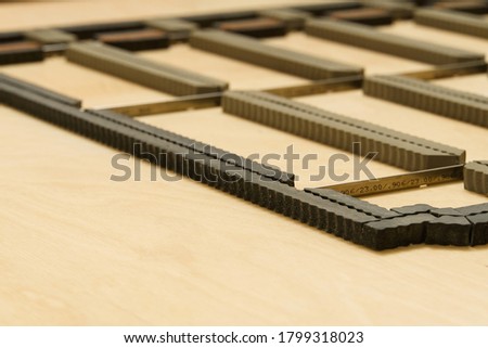 Cutting dies form - polygraph industry, for cutting and folding paper or carton for packing. soft focus. Packaging production die cutting mold. Royalty-Free Stock Photo #1799318023