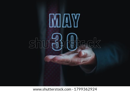 may 30th. Day 30 of month,  announcement of date of  business meeting or event. businessman holds the name of the month and day on his hand.. spring month, day of the year concept.