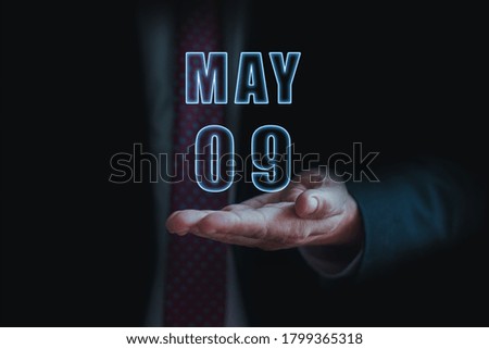 may 9th. Day 9 of month,  announcement of date of  business meeting or event. businessman holds the name of the month and day on his hand.. spring month, day of the year concept.