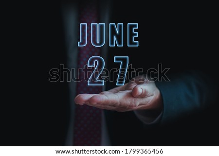 june 27th. Day 27 of month,  announcement of date of  business meeting or event. businessman holds the name of the month and day on his hand.. summer month, day of the year concept.