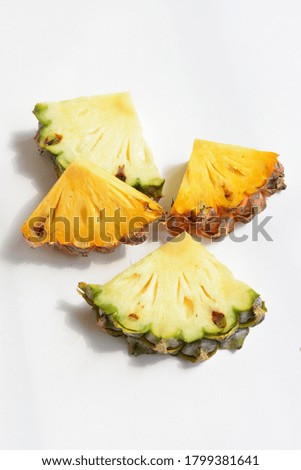 Fresh orange and green pineapples slices/chunks/ pieces/ isolated in white background