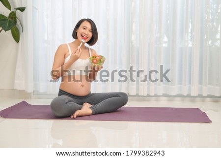 pregnancy, healthy food and people concept - Happy pregnant woman eating vegetable salad 