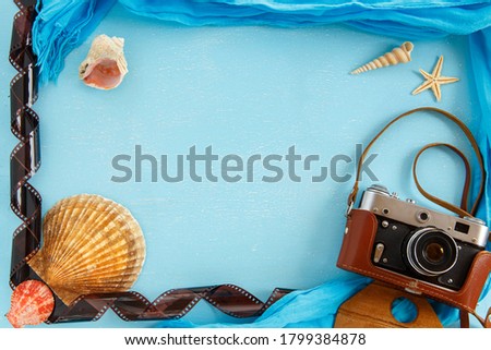 Top view composition - Blank paper photo frame with starfish, shells and items on wooden table. Concept of remembrance and nostalgia in summer tourism, travel and vacation. vintage color tone.