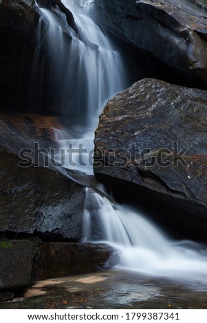 Water flowing between big rocks.