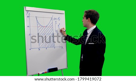 Young intelligent man in suit writing mathematical formula on board against green screen background, People and intelligence concept, chroma key 