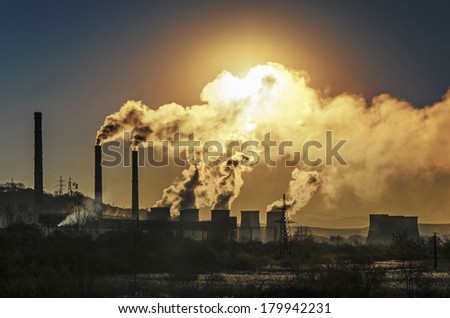 Factory pipe polluting air, smoke from chimneys against sun, environmental problems, ecological theme, industry scene Royalty-Free Stock Photo #179942231