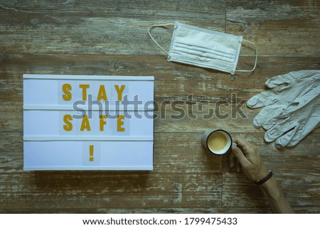 lightbox with stay safe written on wooden background about covid