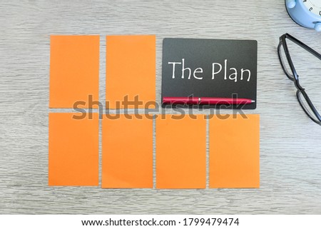 Message on the plan on black chalk board, blank notes, eyeglasses and alarm clock on wooden table 