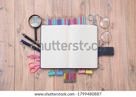Back to school. Items for the school on a wooden table background and notebook space for text