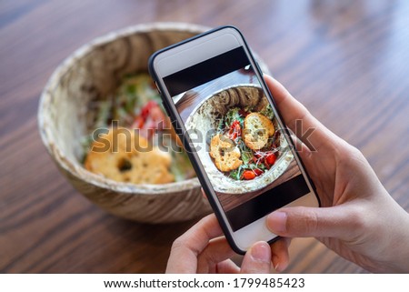 Women use mobile phones to take pictures of food or take live video on social networking applications. Food for dinner looks appetizing. Photography and take picture for review food concepts