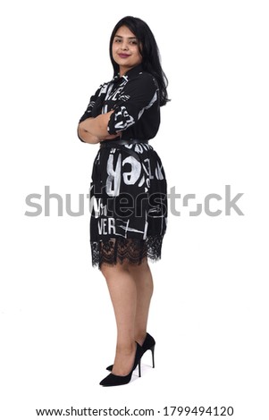 sideways of latin woman with dress and high heels on white background, arms crossed
