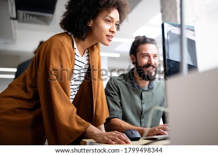 Happy young business people colleagues talking working in office Royalty-Free Stock Photo #1799498344
