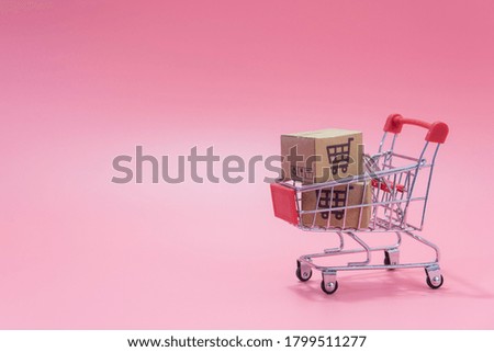Shopping concept : Cartons or Paper boxes in blue shopping cart on pink background. online shopping consumers can shop from home and delivery service. with copy space
