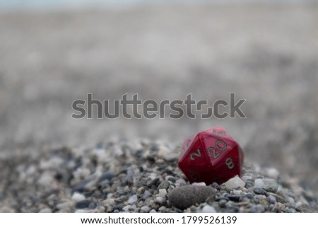 Red Dungeon and Dragons dice with character sheets at the beach