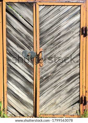 Old wooden gate with the handle in a shape of a heart