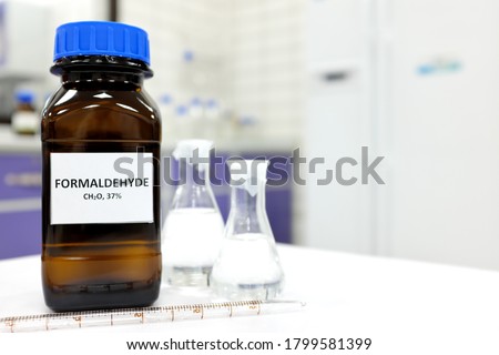 Selective focus of formaldehyde or formalin in brown amber glass bottle inside a laboratory. Blurred background with copy space. Royalty-Free Stock Photo #1799581399