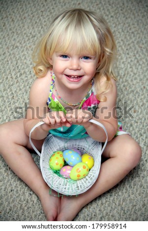 Funny little girl with a basket of Easter eggs 