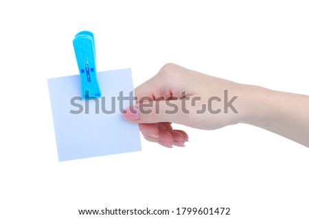 hand holding empty paper for notes with clothespin on white background isolation