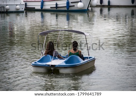 Portrait on back view of women floating on pedalo in the river in the city  Royalty-Free Stock Photo #1799641789
