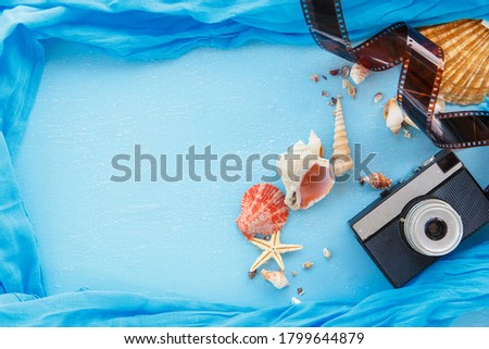 Top view composition - Blank paper photo frames with starfish, shells and items on wooden table. Concept of remembrance and nostalgia in summer tourism, travel and vacation. vintage color tone.