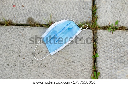 Medical Face Mask Thrown Away as Garbage - Protection from Covid-19 Royalty-Free Stock Photo #1799650816