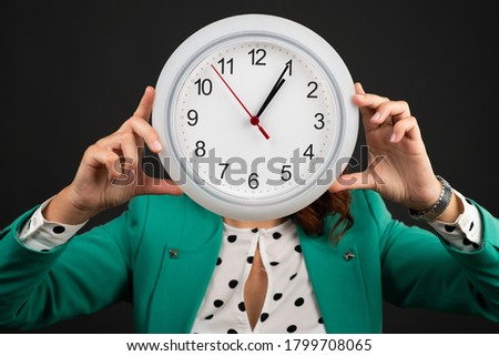 Woman holding a wall clock above her head