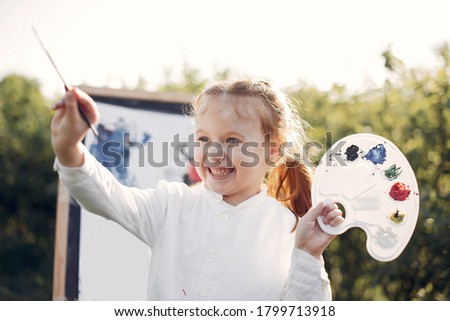 Little girl in a summer park. Cute child drawing