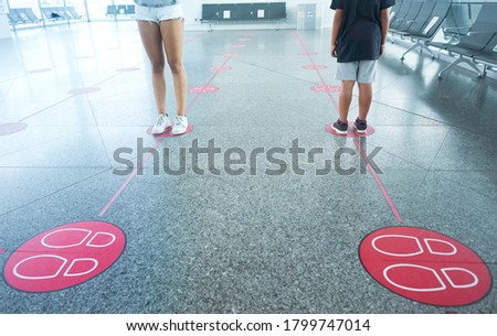 Children waiting on the ground markings to maintain social distancing. Social distance to avoid Covid 19.