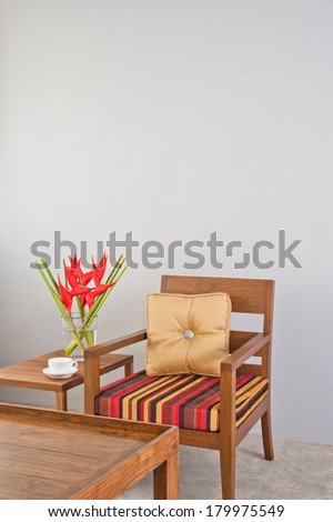 Beige red color striped upholstered chair with side table and flowers 