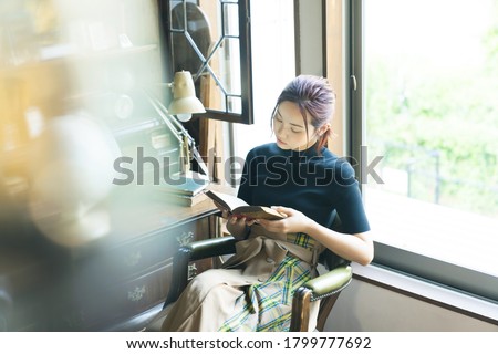 Young asian woman reading a book. Royalty-Free Stock Photo #1799777692