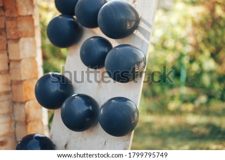 Black balloons filled with helium and glued to a plywood board.