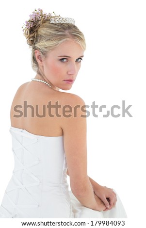Portrait of sensuous bride sitting against white background