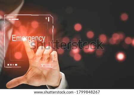 Businessman uses finger touch the word Emergency on fingerprints in the channel graph on the black background Technology Process System Business concept.