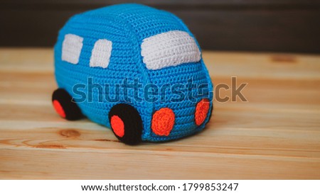 Blue crochet car. Toy for babies and toddlers to learn mechanical skills and colors. Handmade crafts. DIY concept.